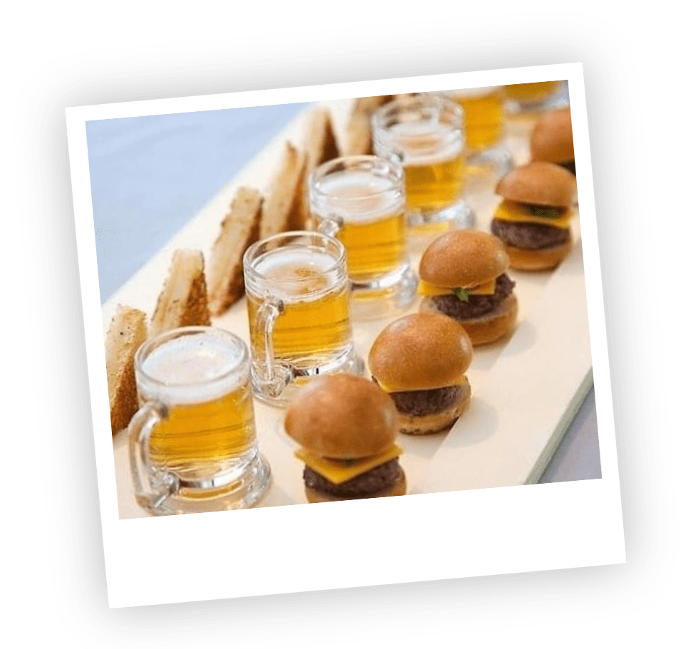 Mini cheeseburgers, beer and sandwiches on a tray